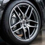 Zbliżenie na srebrną felgę aluminiową Mercedesa z czarną oponą